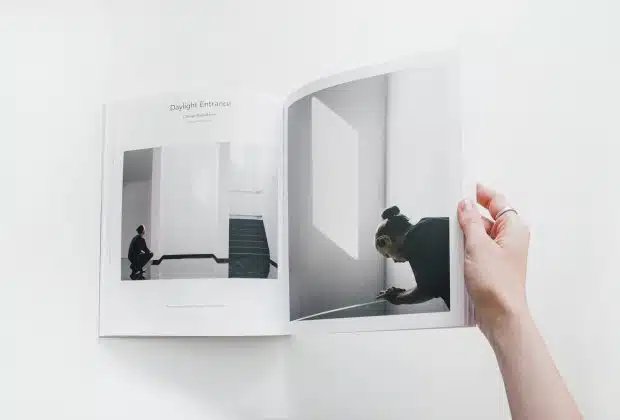 person reading book on white surface